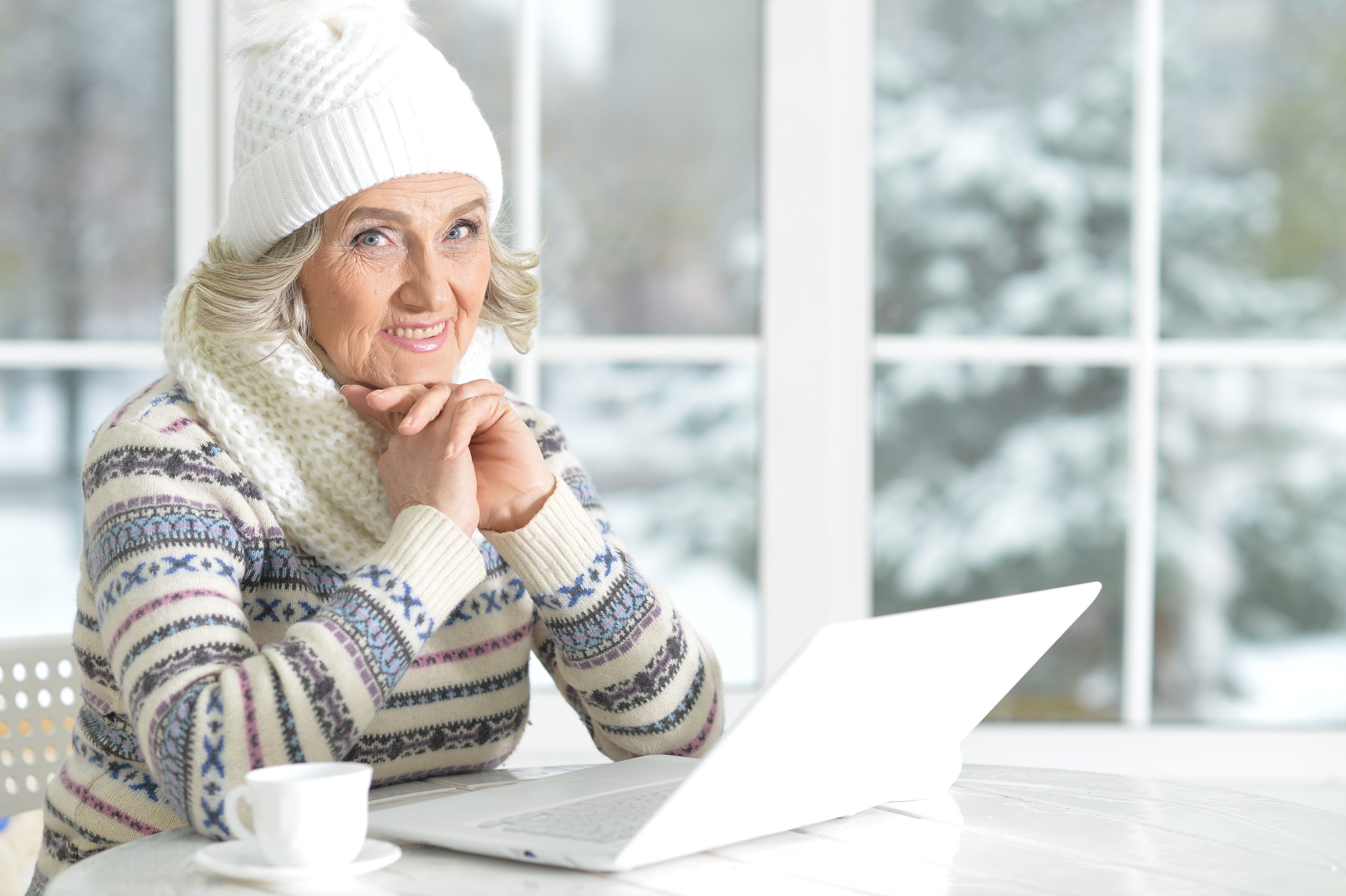 - va home care pennsylvania - senior woman using laptop sitting near window - home care concepts - companionship